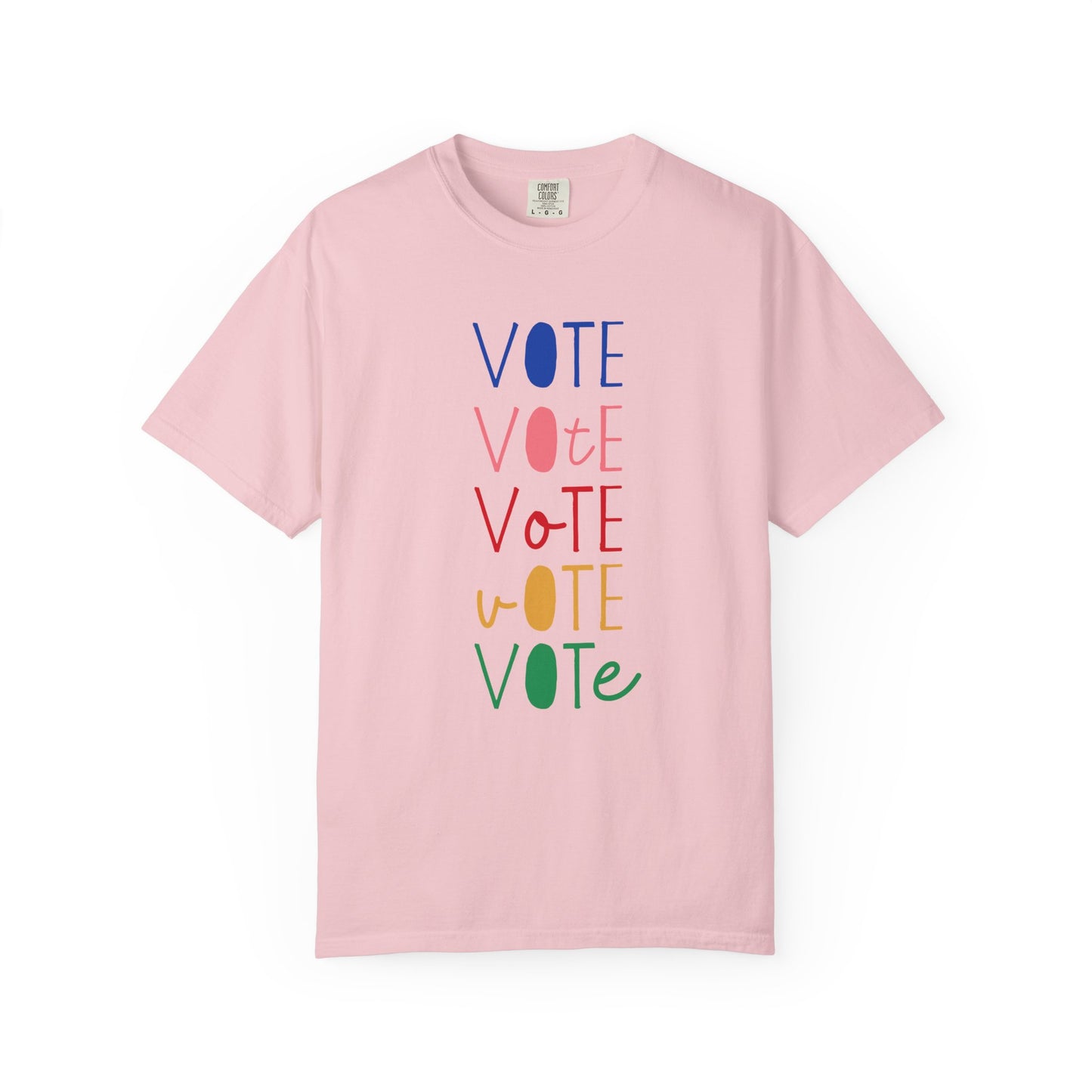 A light pink short-sleeve t-shirt with a vertical graphic spelling 'VOTE' in alternating blue, pink, red, yellow, and green colors, displayed on a clean white background.