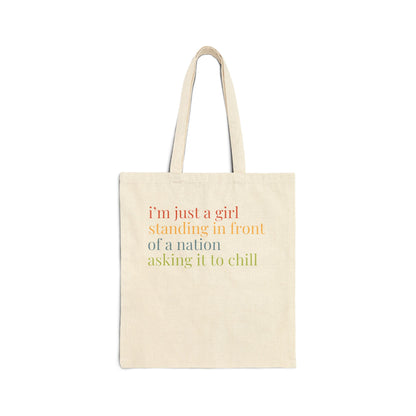 Natural tan canvas tote bag with colorful “I'm just a girl, standing in front of a nation, asking it to chill” text