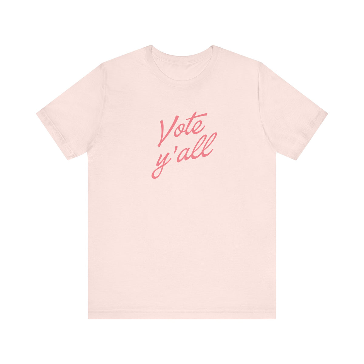 A light pink short-sleeve crewneck t-shirt featuring the phrase 'Vote y'all' printed in a pink cursive font across the chest, displayed on a clean white background.