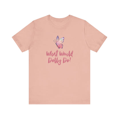 A peach-pink short-sleeve t-shirt with a butterfly graphic and the text 'What Would Dolly Do?' printed on the chest, displayed on a solid white background.