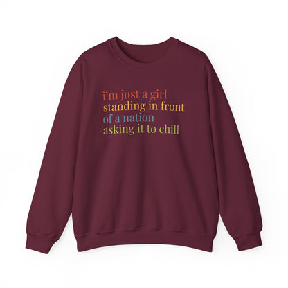 Maroon Unisex crewneck sweatshirt with colorful “I'm just a girl, standing in front of a nation, asking it to chill” text
