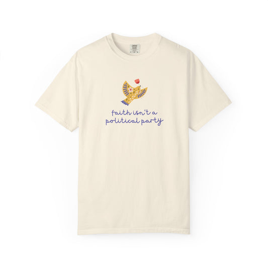 Beige t-shirt with a folk art dove graphic and purple text "faith isn't a political party"