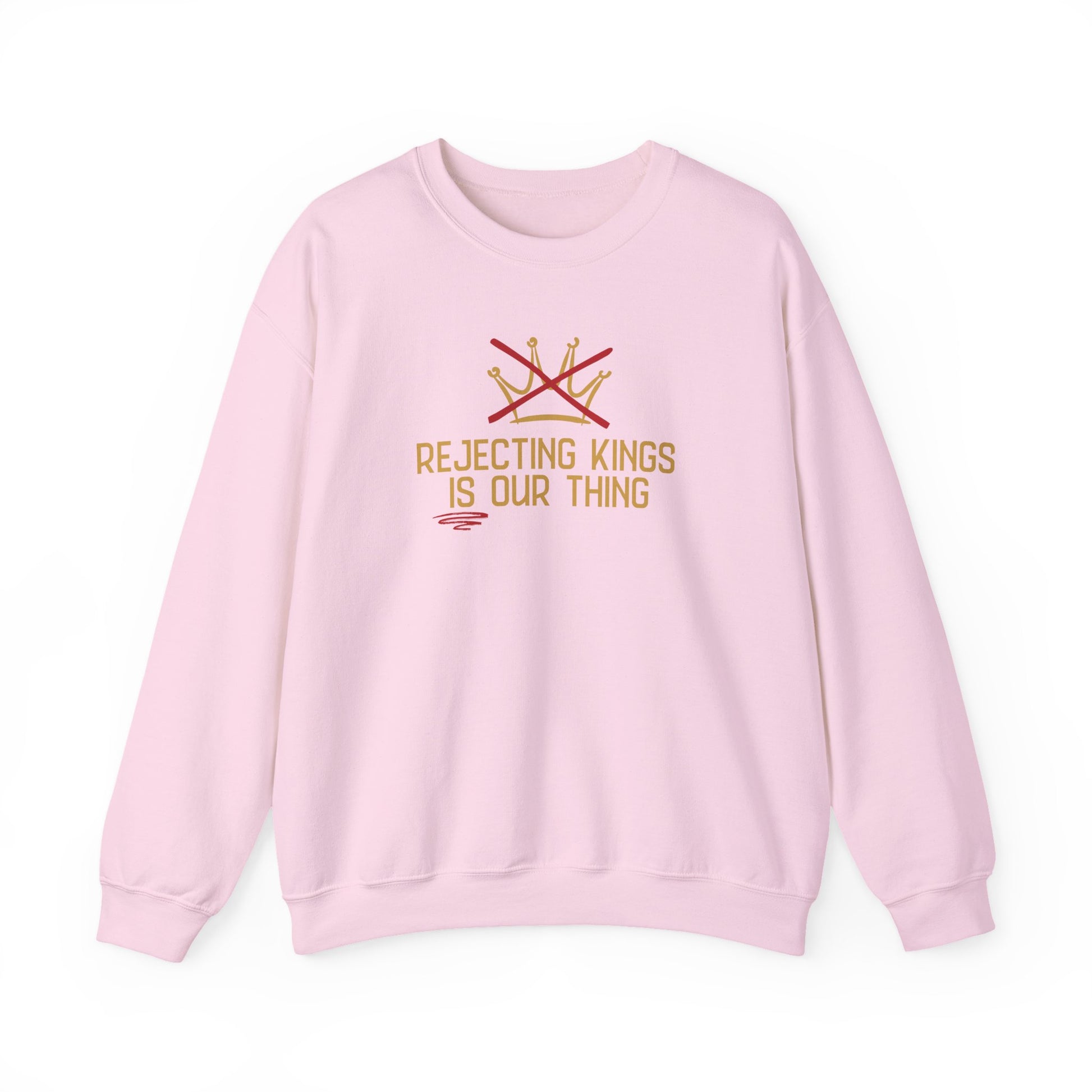 Pink sweatshirt with gold sketch graphic of a crown with a red X over it and gold text "REJECTING KINGS IS OUR THING"
