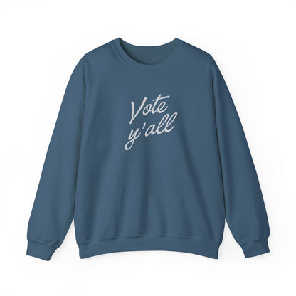 A dark blue crewneck sweatshirt with the words 'Vote y'all' printed in a light gray cursive font on the chest