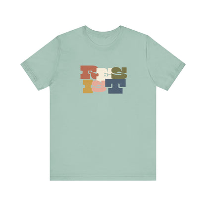 Light green t-shirt with colorful 'RESIST' graphic 