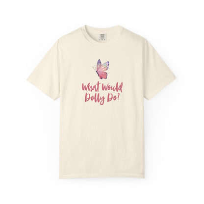 An off-white short-sleeve t-shirt with a pink graphic of a butterfly and the text 'What Would Dolly Do!' printed on the front, displayed against a solid white background.