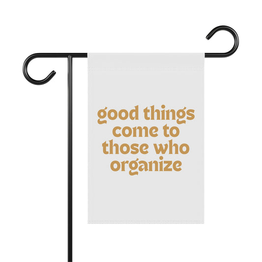 White garden flag with 'good things come to those who organize' gold text
