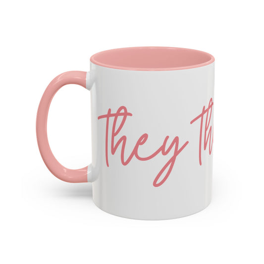 White ceramic 11 oz coffee or tea mug with pink interior and handle, featuring the text "they the people" in pink wraparound