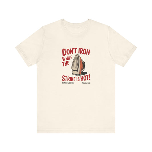 Beige t-shirt with a vintage iron graphic and red text "don't iron while the strike is hot" 