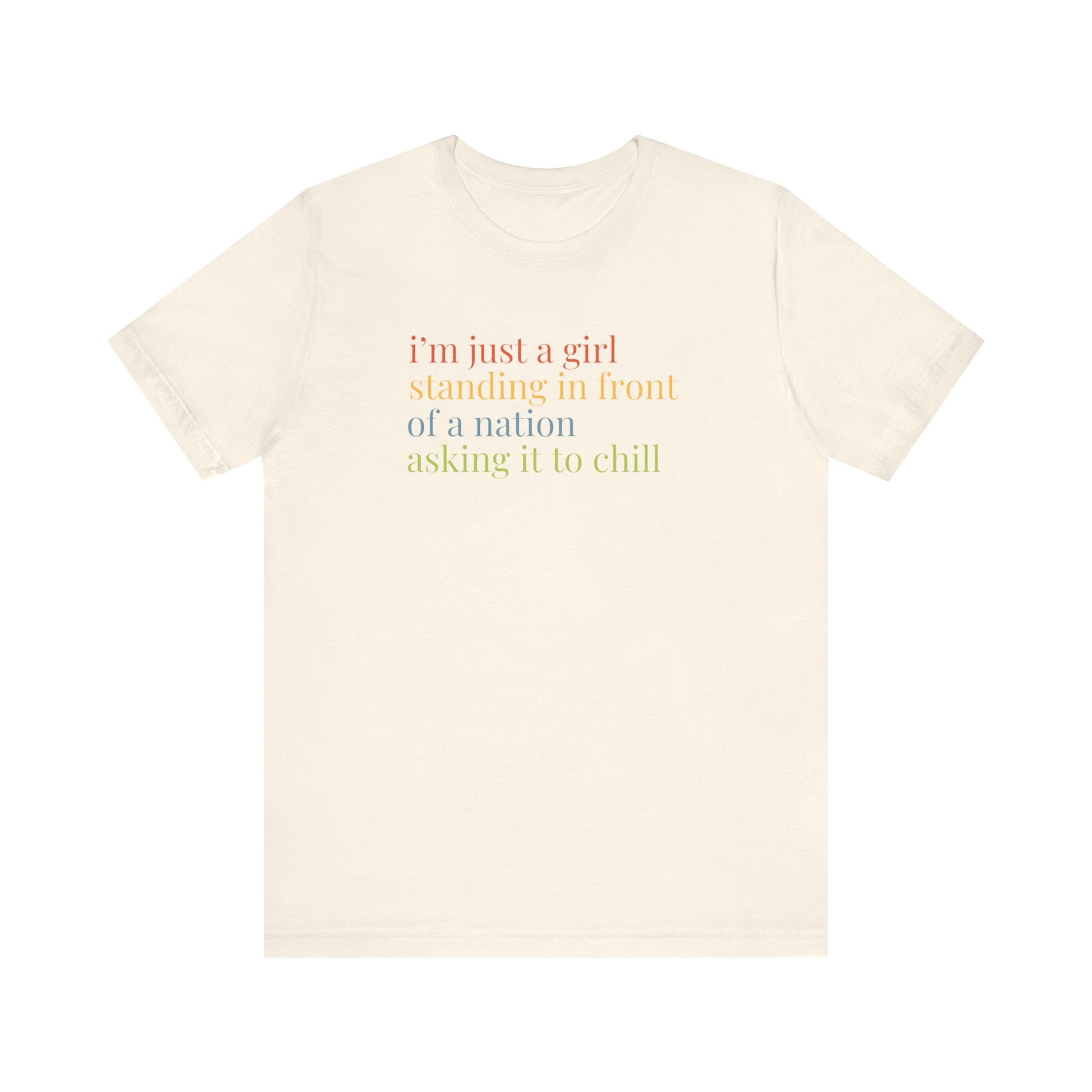 Beige t-shirt with colorful text "i'm just a girl, standing in front of a nation, asking it to chill"