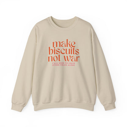 Tan sweatshirt with orange text "make biscuits not war" and smaller pink text underneath "y'all need to leave other folks alone"