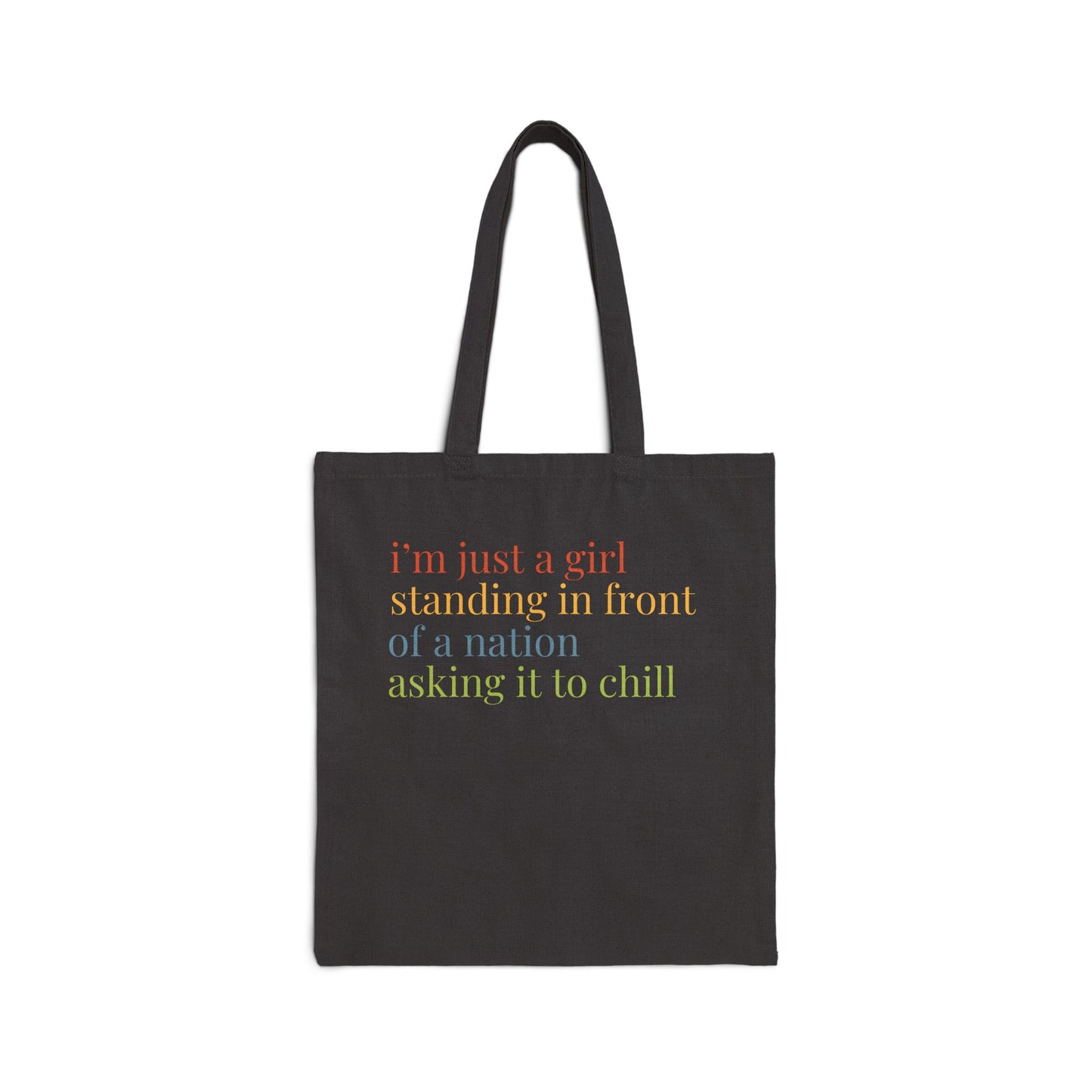 Black canvas tote bag with colorful “I'm just a girl, standing in front of a nation, asking it to chill” text