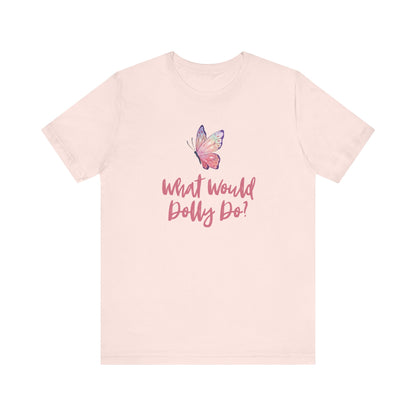 A light pink short-sleeve t-shirt with a graphic on the chest featuring a purple and pink butterfly above the cursive text 'What Would Dolly Do?' in pink, shown against a plain white background.
