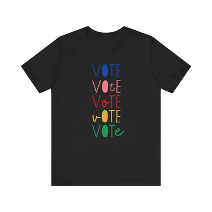 A black short-sleeve t-shirt with a vertical graphic on the chest spelling 'VOTE' in alternating bright colors (blue, pink, red, yellow, green) with oval letterforms, shown on a plain white background.