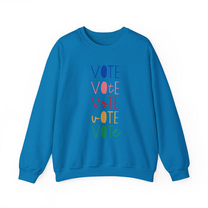 A bright blue crewneck sweatshirt featuring a vertical graphic print of the word 'VOTE' repeated five times in alternating colors: blue, pink, red, yellow, and green.