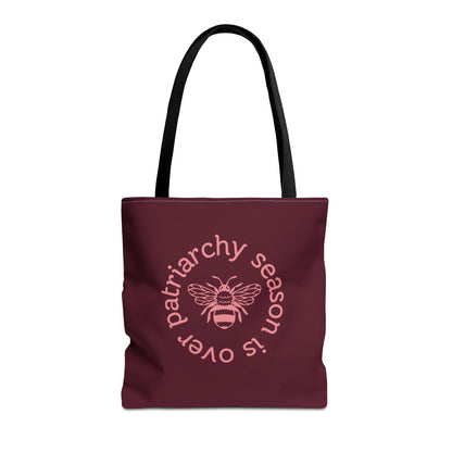 Maroon tote bag with black handles with pink "patriarchy season is over" text circling around a queen bee graphic 