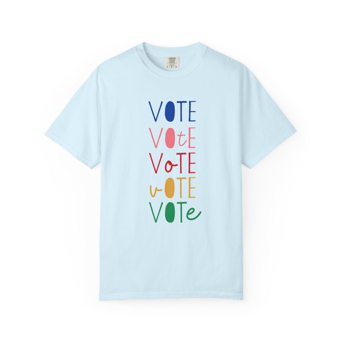 A light blue short-sleeve t-shirt with a vertical graphic spelling 'VOTE' in alternating blue, pink, red, yellow, and green colors, displayed on a clean white background.