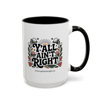 White ceramic coffee or tea mug with black interior and handle, featuring "Y'all Ain't Right" decorative text and floral elements