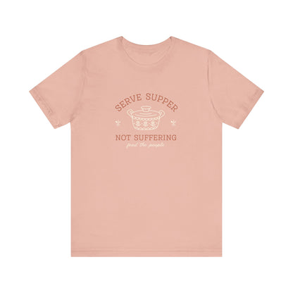 Pink t-shirt with vintage pyrex illustrated graphic and dark orange and white text "serve supper not suffering; feed the people"