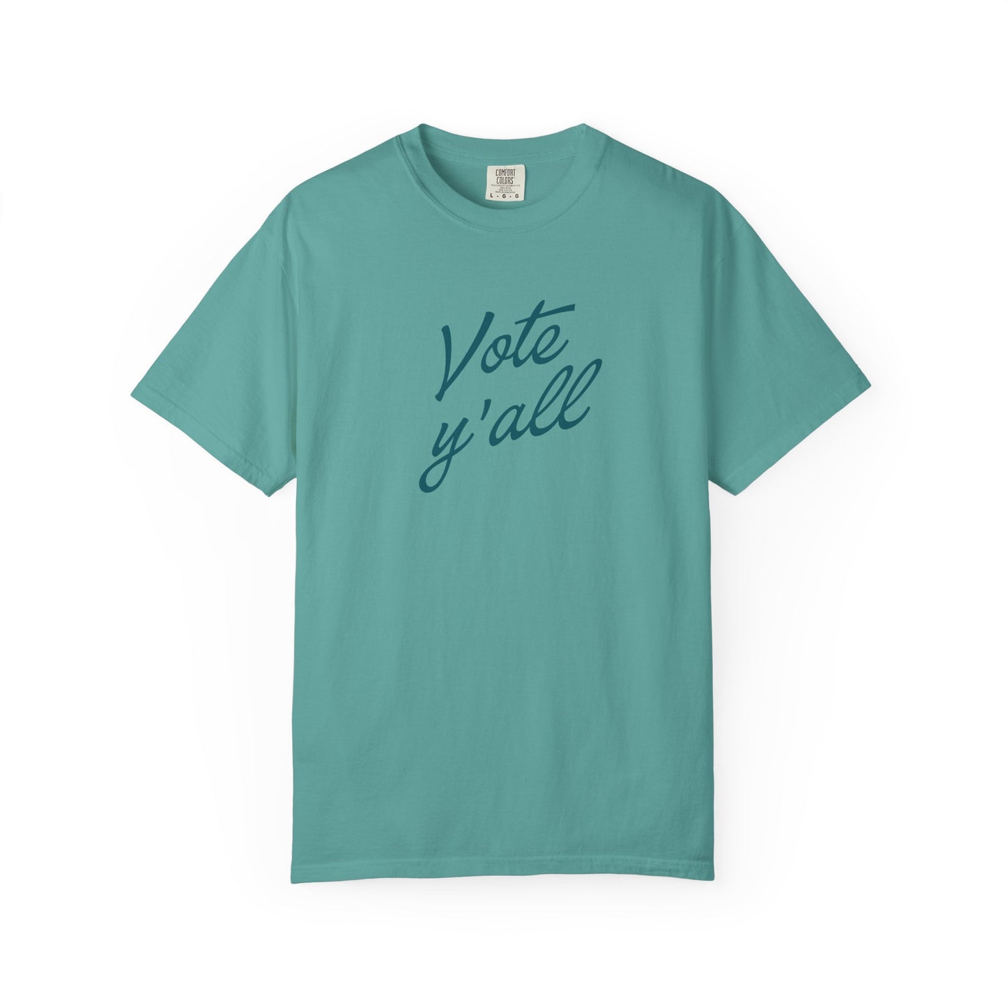 A short-sleeve crewneck t-shirt in a teal blue color, featuring the phrase 'Vote y'all' printed in a darker teal cursive script across the chest, displayed on a clean white background.