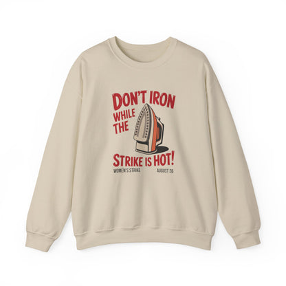 Beige unisex crewneck sweatshirt with "don't iron while the strike is hot" red text and a vintage iron graphic