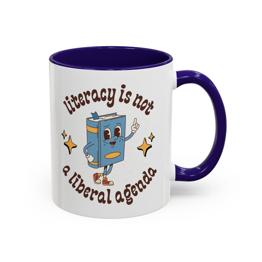 White ceramic 11 oz coffee or tea mug with blue interior and handle with cartoon book character graphic and text 'literacy is not a liberal agenda' 