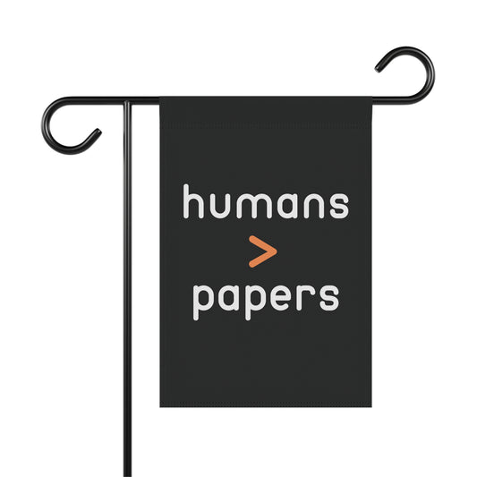 Black garden flag with 'humans > papers' white text