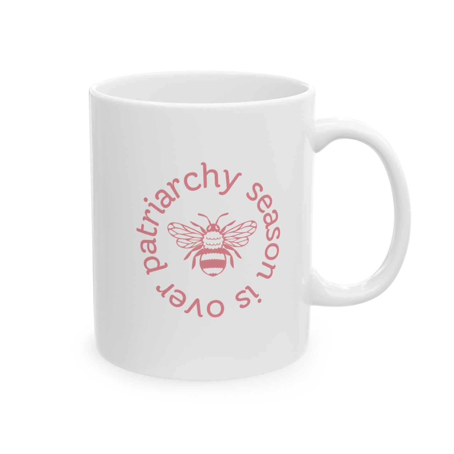 White ceramic 11 oz coffee or tea mug with pink "patriarchy season is over" text circling around a queen bee graphic 