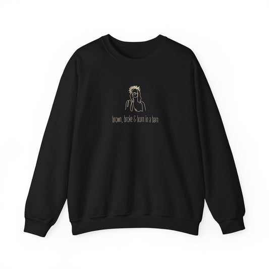 Black unisex crewneck sweatshirt with a sketch graphic of Jesus and "brown, broke & born in a barn" cream text