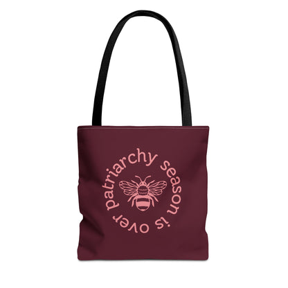 Maroon tote bag with black handles with pink "patriarchy season is over" text circling around a queen bee graphic 