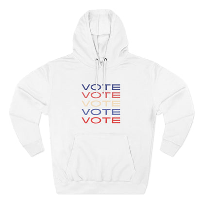 A white pullover hoodie with a front kangaroo pocket and drawstring hood, featuring a stacked 'VOTE' graphic in blue, red, and cream on the chest, displayed on a clean white background.