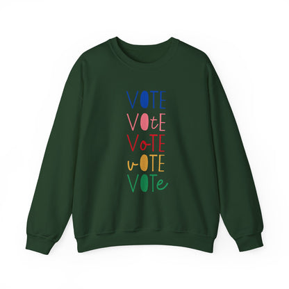 A dark green crewneck sweatshirt featuring a vertical graphic print of the word 'VOTE' repeated five times in alternating colors: blue, pink, red, yellow, and green.