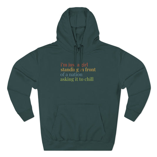 Teal hoodie with colorful text "i'm just a girl standing in front of a nation asking it to chill"