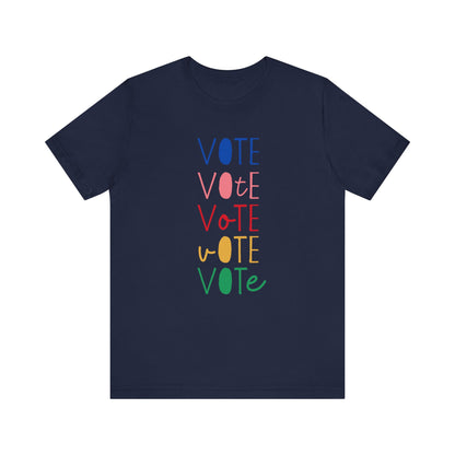 A navy blue short-sleeve t-shirt with a vertical graphic on the chest spelling 'VOTE' in alternating bright colors (blue, pink, red, yellow, green) with oval letterforms, shown on a plain white background.