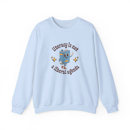 Light blue unisex crewneck sweatshirt with retro book character graphic and "literacy is not a liberal agenda" brown text