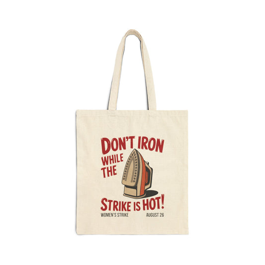 Beige canvas tote bag with "don't iron while the strike is hot" red text and a vintage iron graphic