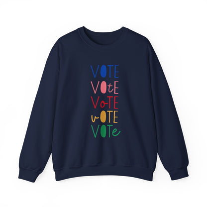 A navy blue crewneck sweatshirt featuring a vertical graphic print of the word 'VOTE' repeated five times in alternating colors: blue, pink, red, yellow, and green.