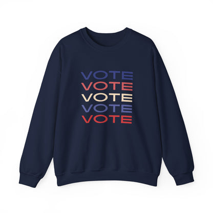 A navy blue crewneck sweatshirt featuring a stacked graphic print of the word 'VOTE' in blue, red, and beige, displayed on a clean white background.