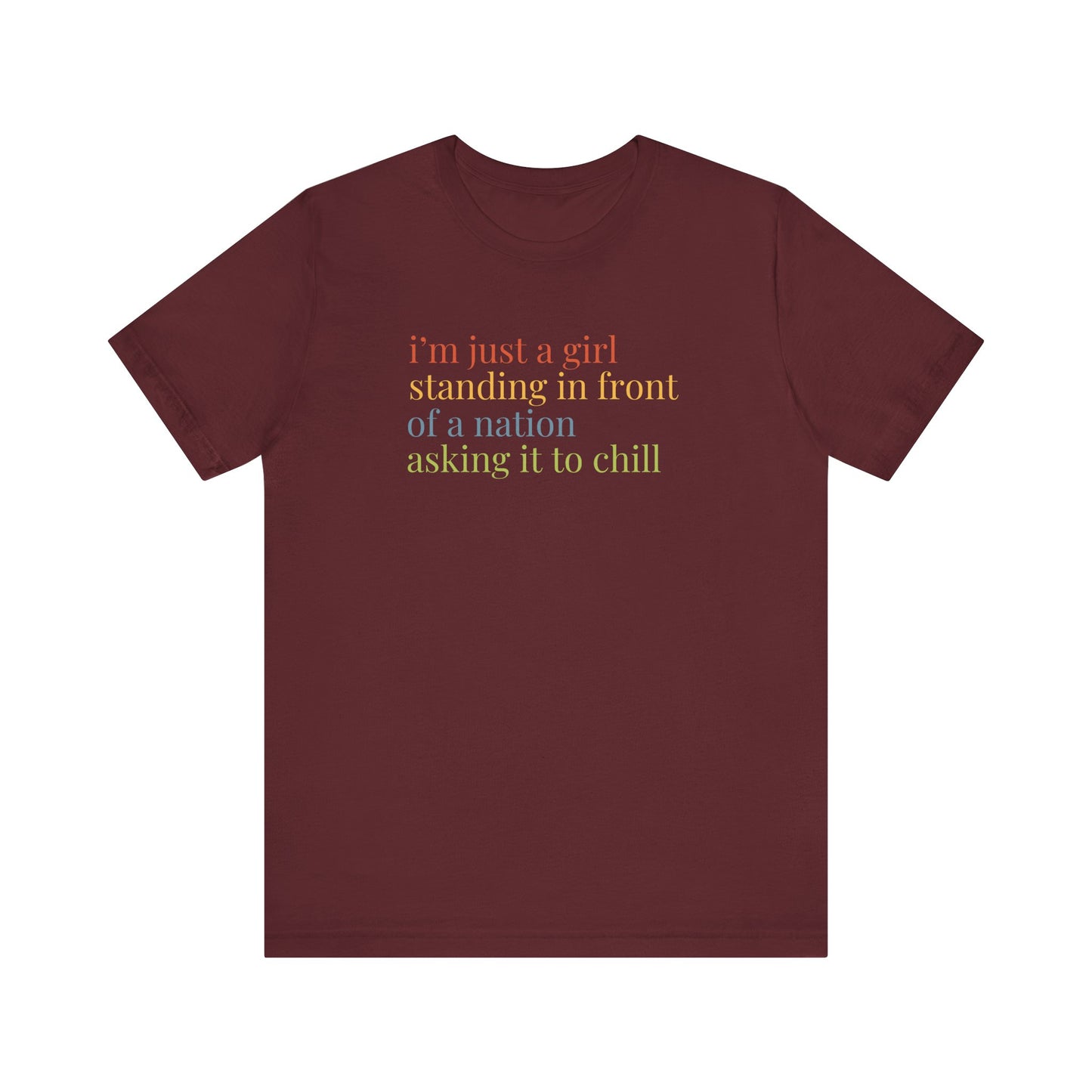 Maroon t-shirt with colorful text "i'm just a girl, standing in front of a nation, asking it to chill"