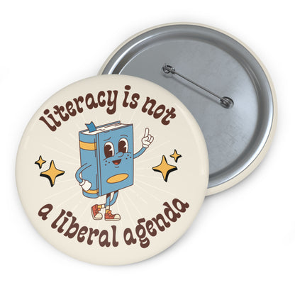 Cream pin button with book character  graphic and text 'Literacy is not a liberal agenda' 