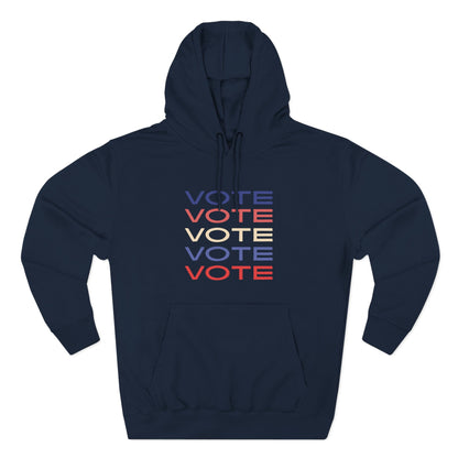 A navy blue pullover hoodie with a front kangaroo pocket and drawstring hood, featuring a stacked 'VOTE' graphic in blue, red, and cream on the chest, displayed on a clean white background.