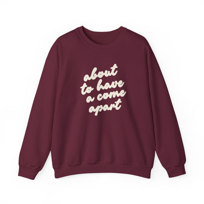 Maroon sweatshirt with "about to have a come apart" in cream text