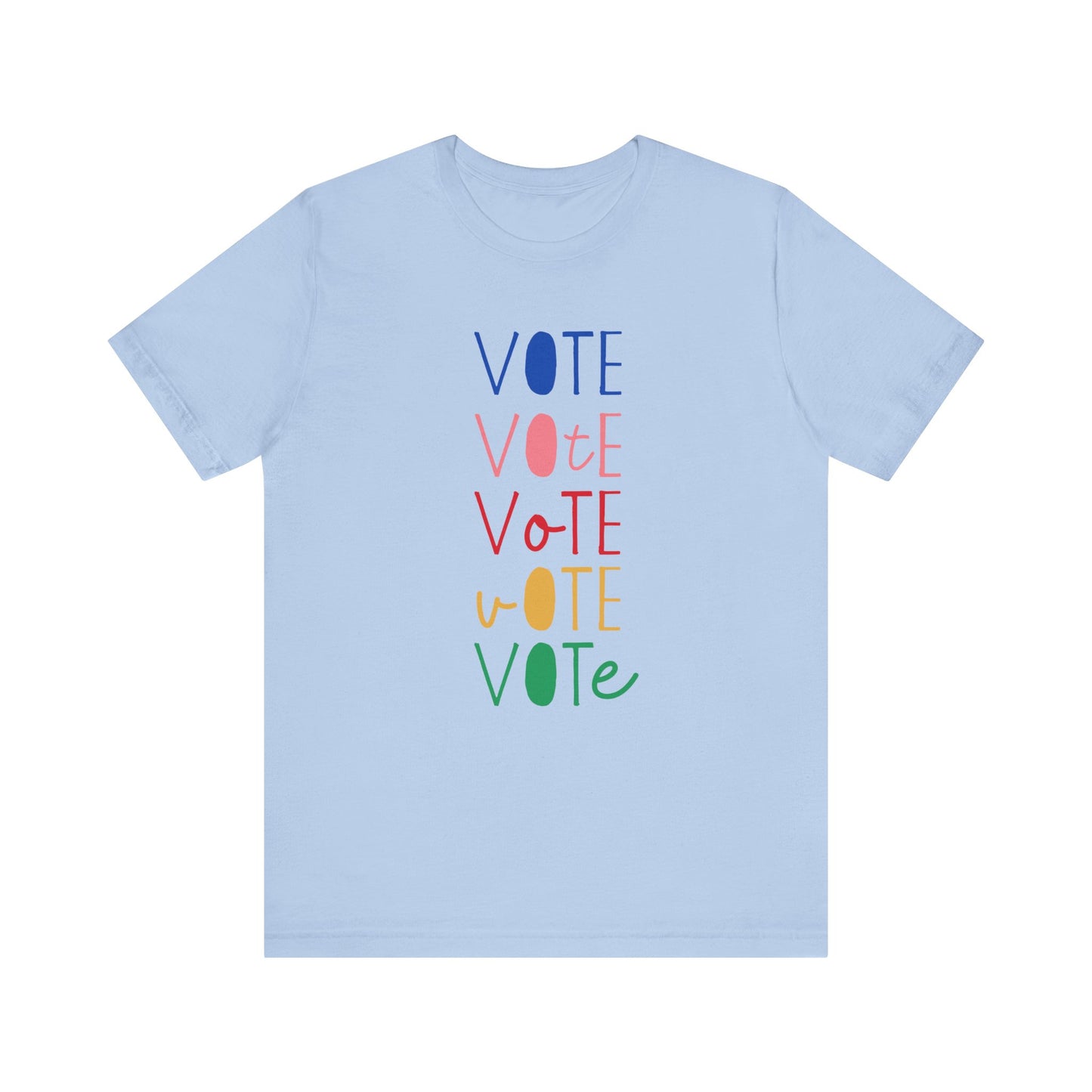 A light blue short-sleeve t-shirt with a vertical graphic on the chest spelling 'VOTE' in alternating bright colors (blue, pink, red, yellow, green) with oval letterforms, shown on a plain white background.