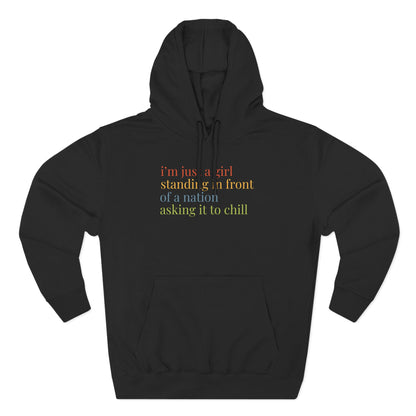 Black hoodie with colorful text "i'm just a girl standing in front of a nation asking it to chill"