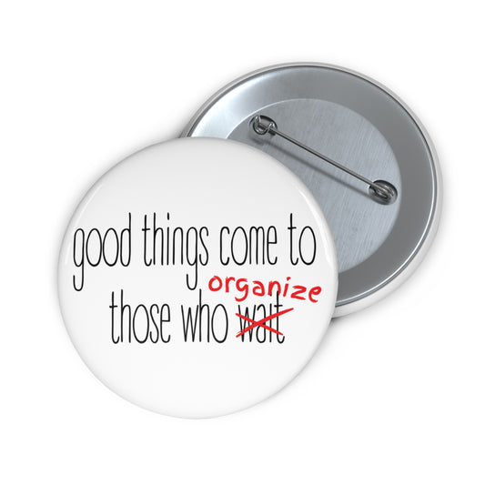 White pin button with text 'good things come to those who wait (organize)' in black and red