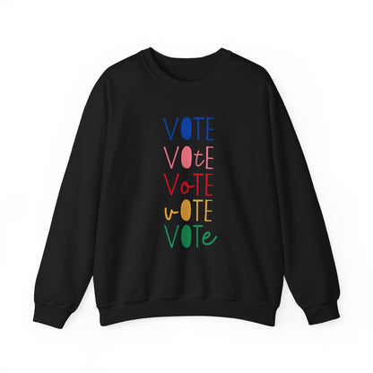 A black crewneck sweatshirt featuring a vertical graphic print of the word 'VOTE' repeated five times in alternating colors: blue, pink, red, yellow, and green.