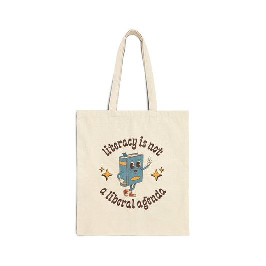 Tote bag with cartoon book character and text 'Literacy is not a liberal agenda' on a white background