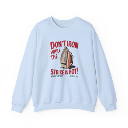 Light blue unisex crewneck sweatshirt with "don't iron while the strike is hot" red text and a vintage iron graphic
