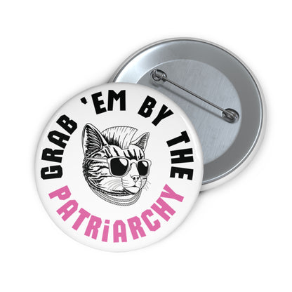 White button with punk rock cat and black and pink text "grab 'em by the patriarchy"