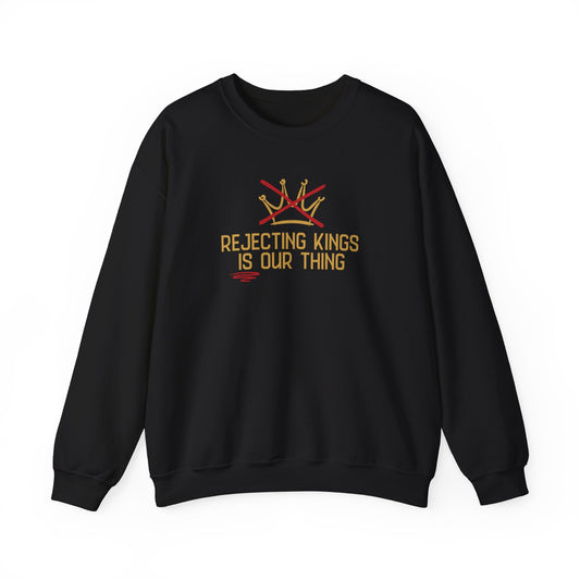 Black sweatshirt with gold sketch graphic of a crown with a red X over it and gold text "REJECTING KINGS IS OUR THING"